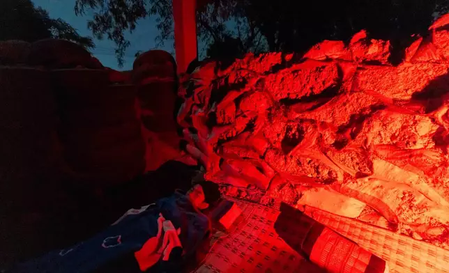 Thai people, who fled clashes between Thai and Cambodian soldiers, takes shelter in Buriram province, Thailand, Tuesday, Dec. 9, 2025. (AP Photo/Wason Wanichakorn)