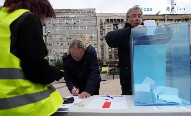 Serbia's protesting university students collect signatures for their request for an early parliamentary election, in Belgrade, Serbia, Sunday, Dec. 28, 2025. (AP Photo/Darko Vojinovic)