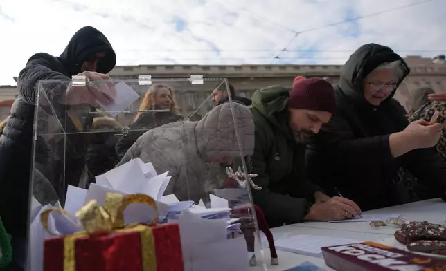 Serbia's protesting university students collect signatures for their request for an early parliamentary election, in Belgrade, Serbia, Sunday, Dec. 28, 2025. (AP Photo/Darko Vojinovic)