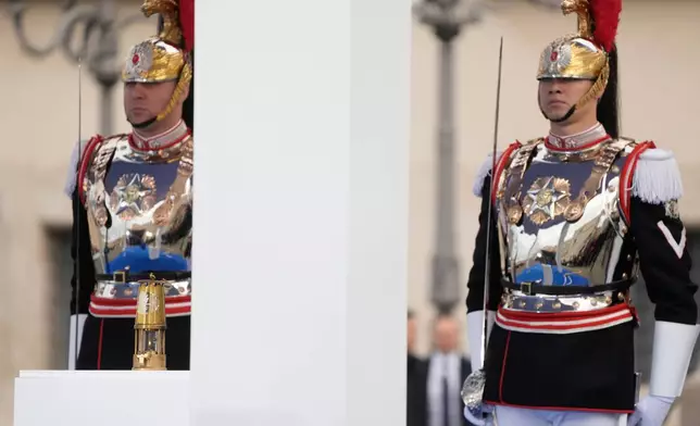Cuirassiers stand next to the torch lantern prior to the Milan Cortina 2026 Winter Olympics cauldron lighting, in front of the Quirinale Presidential Palace, in Rome, Friday Dec. 5, 2025. (AP Photo/Gregorio Borgia)