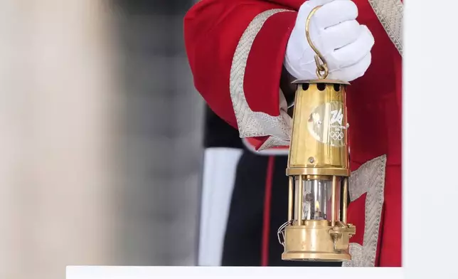 A cuirassier holds the torch lantern prior to the Milan Cortina 2026 Winter Olympics cauldron lighting, in front of the Quirinale Presidential Palace, in Rome, Friday Dec. 5, 2025. (AP Photo/Gregorio Borgia)