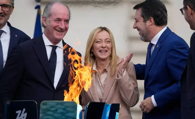 Italy's Prime Minister Giorgia Meloni, center is flanked by Veneto region President Luca Zaia, left, and vice president of Italy's Council of Ministers Matteo Salvini attend the Milan Cortina 2026 Winter Olympics cauldron lighting, in front of the Quirinale Presidential Palace, in Rome, Friday Dec. 5, 2025. (AP Photo/Gregorio Borgia)