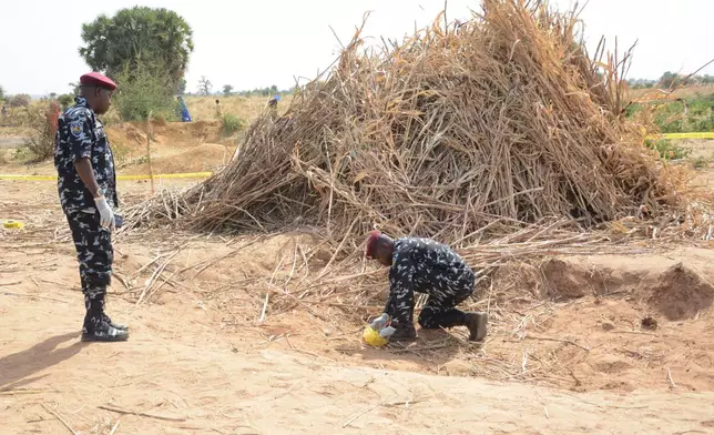 Police Anti-Bomb squad inspect the site of a U.S. airstrike in Northwest, Jabo, Nigeria, Friday, Dec. 26, 2025. (AP Photo/ Tunde Omolehin)