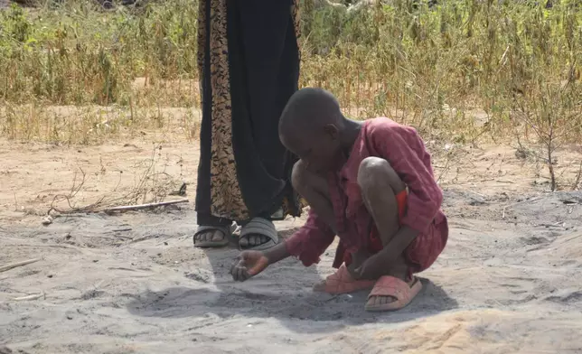 A boy picks debris at the site of a U.S. airstrike in Northwest, Jabo, Nigeria, Friday, Dec. 26, 2025. (AP Photo/ Tunde Omolehin)