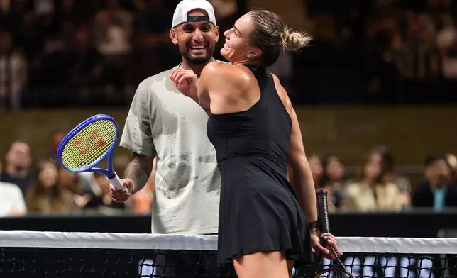 Nick Kyrgios, left, and Aryna Sabalenka interact at the net during their Battle of the Sexes match, in Dubai, United Arab Emirates, Sunday Dec. 28, 2025. (Christopher Pike/Pool Photo via AP)