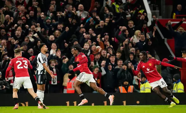 Manchester United's Patrick Dorgu, center, celebrates after scoring the opening goal during the English Premier League soccer match between Manchester United and Newcastle in Manchester, England, Friday, Dec. 26, 2025. (AP Photo/Dave Thompson)