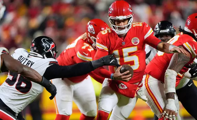 Kansas City Chiefs quarterback Patrick Mahomes (15) scrambles as Houston Texans defensive end Denico Autry, left, defends during the first half of an NFL football game Sunday, Dec. 7, 2025, in Kansas City, Mo. (AP Photo/Charlie Riedel)