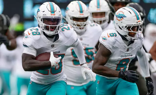 Miami Dolphins running back De'Von Achane (28) carries the ball against the New York Jets during the first quarter of an NFL football game, Sunday, Dec. 7, 2025, in East Rutherford, N.J. (AP Photo/Adam Hunger)