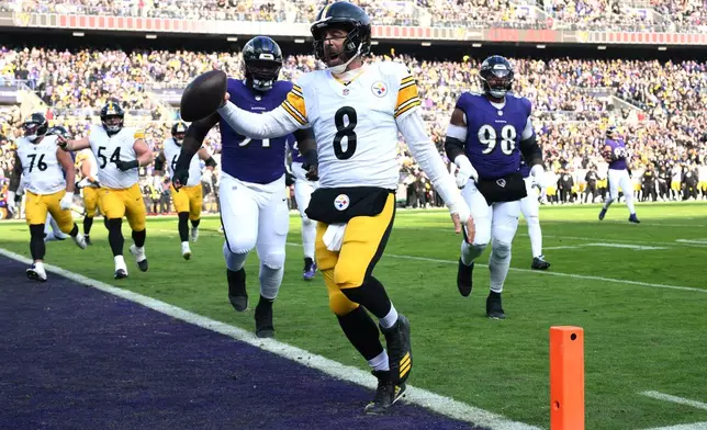 Pittsburgh Steelers quarterback Aaron Rodgers (8) runs to the end zone for a touchdown during the first half of an NFL football game against the Baltimore Ravens, Sunday, Dec. 7, 2025, in Baltimore. (AP Photo/Nick Wass)