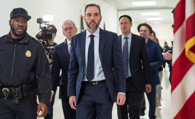 Former Department of Justice Special Counsel Jack Smith, center, and his attorney Lanny Breuer, center rear, arrive at a hearing room in the Rayburn House Office Building after a break in his deposition before the House Judiciary Committee, part of its oversight into DOJ investigations into President Donald Trump, on Capitol Hill in Washington, Wednesday, Dec. 17, 2025. (AP Photo/J. Scott Applewhite)