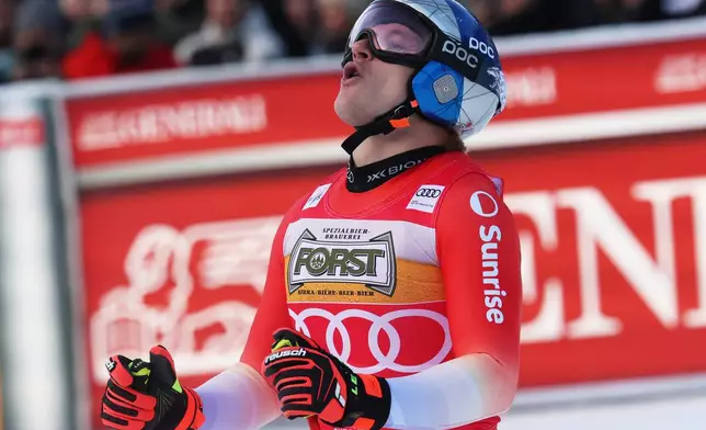 Switzerland's Marco Odermatt celebrates at the finish area of an alpine ski, men's World Cup downhill, in Val Gardena, Italy, Saturday, Dec. 20, 2025. (AP Photo/Alessandro Trovati)