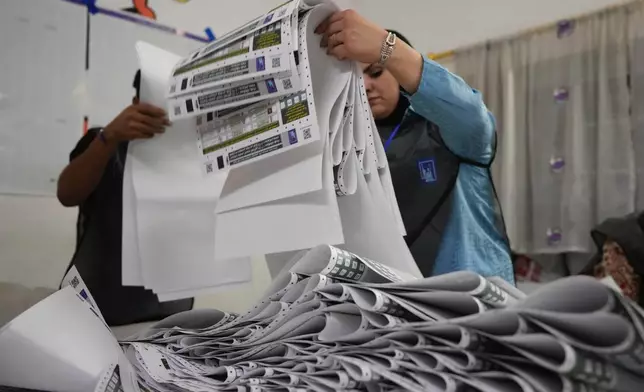 FILE - Election workers gather parliamentary election ballots after the polls closed in Baghdad, Iraq, Nov. 11, 2025. (AP Photo/Hadi Mizban, File)