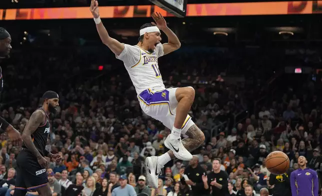 Los Angeles Lakers center Jaxson Hayes, center, reacts after dunking against the Phoenix Suns during the first half of an NBA basketball game, Sunday, Dec. 14, 2025, in Phoenix. (AP Photo/Rick Scuteri)