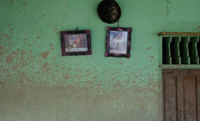 Water level mark is visible on a wall of a house where family photos hang at a village affected by a flash flood in Batang Toru, North Sumatra, Indonesia, Tuesday, Dec. 2, 2025. (AP Photo/Binsar Bakkara)