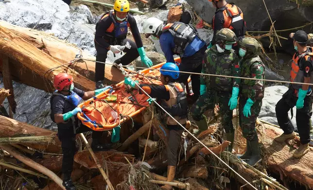 Rescuers use ropes to evacuate the body of a flood victim in Tanah Datar, West Sumatra, Indonesia, Monday, Dec. 1, 2025. (AP Photo/Nazar Chaniago)