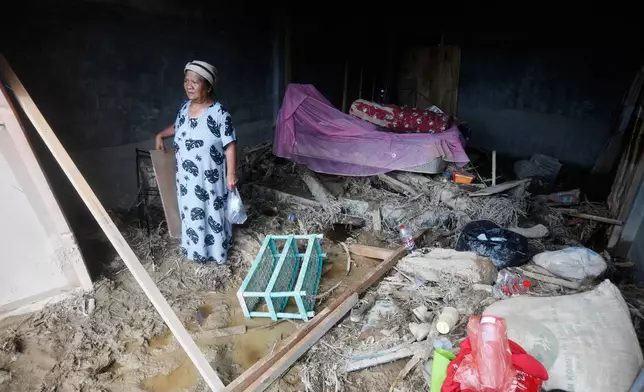 A woman stands inside a damaged house in a village affected by a flash flood in Batang Toru, North Sumatra, Indonesia, Monday, Dec. 1, 2025. (AP Photo/Binsar Bakkara)