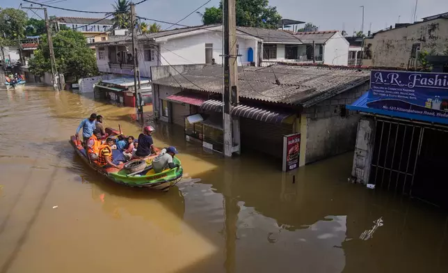 Rescuers move people to safety in a submerged area of Colombo, Sri Lanka, following flooding on Sunday, Nov. 30, 2025. (AP Photo/Eranga Jayawardena)