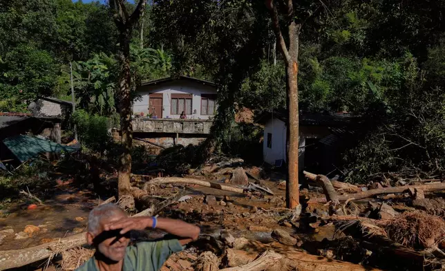 Landslide survivors look at the damages caused by the rain and landslides in Sarasavigama village in Kandy, Sri Lanka, Monday, Dec. 1, 2025. (AP Photo/Eranga Jayawardena)