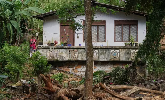 Landslide survivors look at the damages caused by the rain and landslides in Sarasavigama village in Kandy, Sri Lanka, Monday, Dec. 1, 2025. (AP Photo/Eranga Jayawardena)