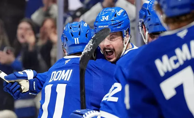 Toronto Maple Leafs center Auston Matthews (34) celebrates his goal with teammate Max Domi (11) during the second period of an NHL hockey game against the Ottawa Senators, in Toronto, Saturday, Dec. 27, 2025. (Frank Gunn/The Canadian Press via AP)