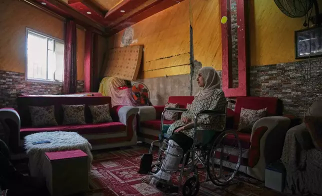 Haneen al-Mabhouh, 34, who lost her leg in an Israeli strike on her home that also killed all four of her daughters, including her 5-month-old baby, sits in a wheelchair in her family home in Nuseirat, central Gaza Strip, Thursday, Nov. 6, 2025. (AP Photo/Abdel Kareem Hana)