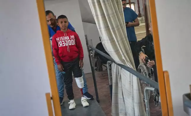 Fadi al-Balbisi, 12, whose right leg was amputated after a shell fired by the Israeli army on April 28, receives rehabilitation training with a prosthetic leg at Hamad Hospital in Zawaida, central Gaza Strip, Thursday, Dec. 4, 2025. (AP Photo/Abdel Kareem Hana)