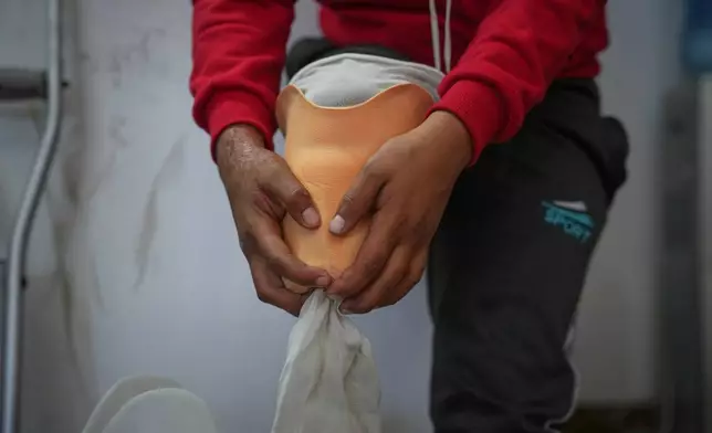 Fadi al-Balbisi, 12, whose right leg was amputated after a shell fired by the Israeli army April 28, tries a prosthetic limb during rehabilitation training at Hamad Hospital in Zawaida, central Gaza Strip, Thursday, Dec. 4, 2025. (AP Photo/Abdel Kareem Hana)