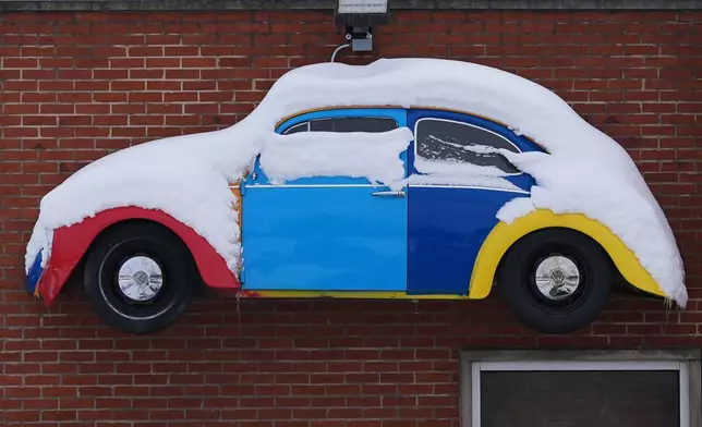 A snow-covered sign hangs on a shop in Northbrook, Ill., Tuesday, Dec. 2, 2025. (AP Photo/Nam Y. Huh)