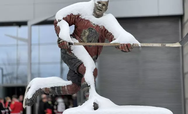A statue of former Chicago Blackhawks' Bobby Hull is covered in snow before a NHL hockey game between the Chicago Blackhawks and the Anaheim Ducks, Sunday, Nov. 30, 2025, in Chicago. (AP Photo/David Banks)