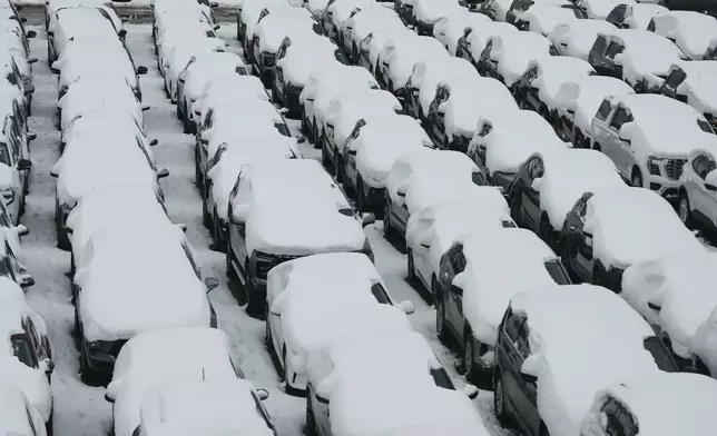Snow covered vehicles sit in a rental car parking lot at O'Hare International Airport in Chicago, Sunday, Nov. 30, 2025. (AP Photo/Nam Y. Huh)