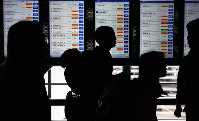 Travelers walk though the terminal at O'Hare International Airport, in Chicago, Sunday, Nov. 30, 2025. (AP Photo/Nam Y. Huh)
