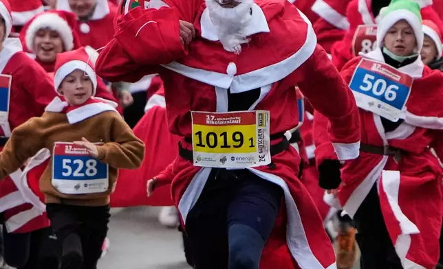 FILE - Participants attend the yearly Santa Claus Run in Michendorf near Berlin, Germany , Sunday, Dec. 7, 2025. (AP Photo/Markus Schreiber, File)
