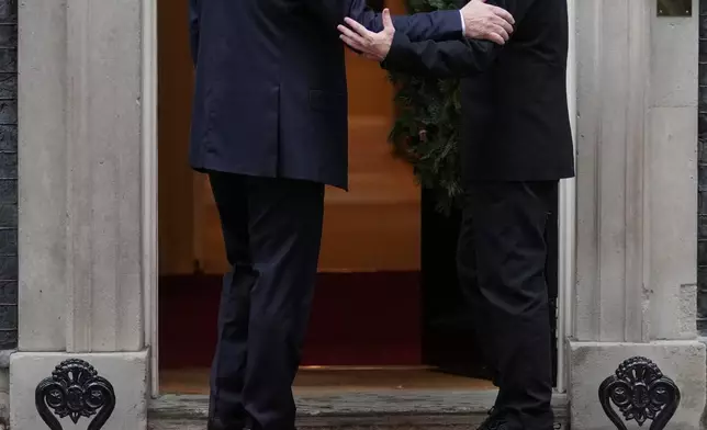 FILE - Britain's Prime Minister Keir Starmer greets Ukrainian President Volodymyr Zelenskyy, on the doorstep of 10 Downing Street, London, Monday, Dec. 8, 2025, as Larry the cat, Chief Mouser to the Cabinet Office walks past. (AP Photo/Kin Cheung, File)