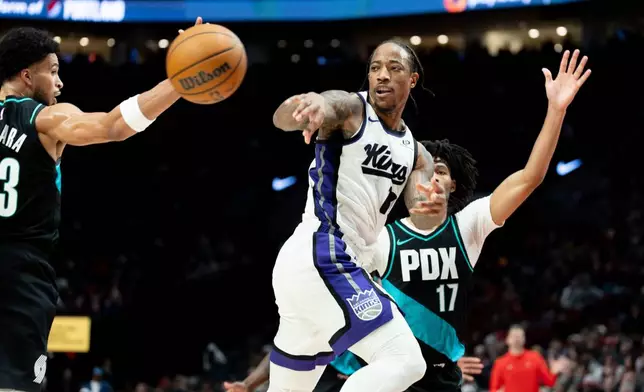 Sacramento Kings guard Demar Derozan, center, passes the ball against the Portland Trail Blazers during the first half of an NBA basketball game Thursday Dec. 18, 2025, in Portland, Ore. (AP Photo/Howard Lao)