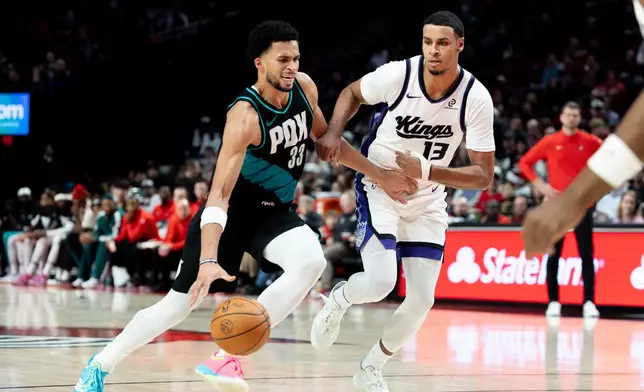 Portland Trail Blazers forward Toumani Camara, left, dribbles against Sacramento Kings forward Keegan Murray during the second half of an NBA basketball game, Thursday Dec. 18, 2025, in Portland, Ore. (AP Photo/Howard Lao)