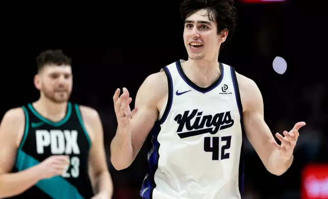 Sacramento Kings center Maxime Raynaud, right, reacts to the foul call during the second half of an NBA basketball game against the Portland Trail Blazers Thursday Dec. 18, 2025, in Portland, Ore. (AP Photo/Howard Lao)
