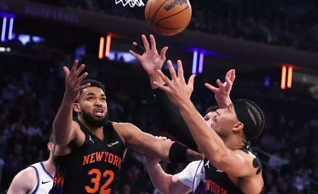 New York Knicks center Karl-Anthony Towns (32) and teammate Josh Hart, right, reach up for the ball during the first half of an NBA basketball game against the Utah Jazz, Friday, Dec. 5, 2025, in New York. (AP Photo/Heather Khalifa)