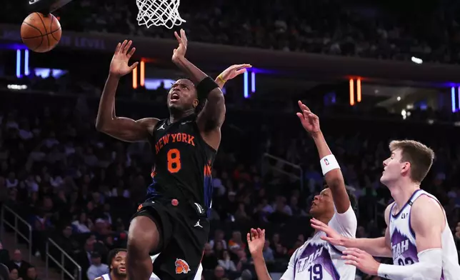 New York Knicks forward OG Anunoby (8) is fouled by Utah Jazz defenders during the second half of an NBA basketball game, Friday, Dec. 5, 2025, in New York. (AP Photo/Heather Khalifa)