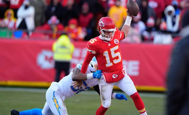 Kansas City Chiefs quarterback Patrick Mahomes (15) is pushed out of bounds by Los Angeles Chargers outside linebacker Khalil Mack, left, during the second half of an NFL football game Sunday, Dec. 14, 2025, in Kansas City, Mo. (AP Photo/Charlie Riedel)