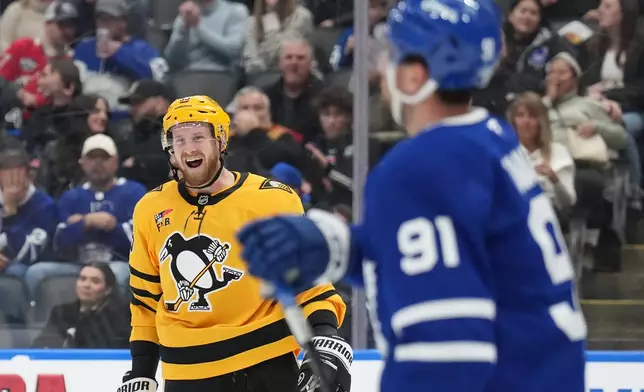 Pittsburgh Penguins forward Anthony Mantha (39) celebrates a goal as Toronto Maple Leafs forward John Tavares (91) looks on during the third period of an NHL hockey game in Toronto, Tuesday, Dec. 23, 2025. (Nathan Denette/The Canadian Press via AP)