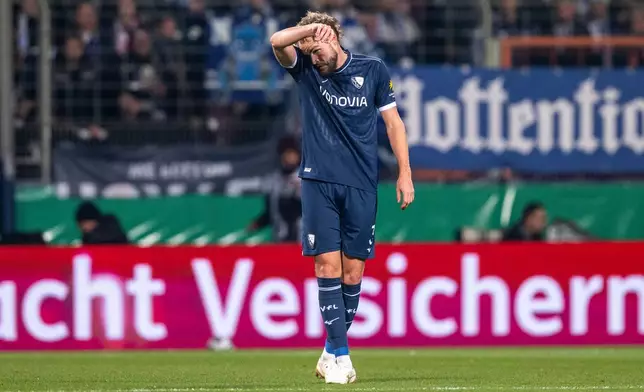 Bochum's Philipp Strompf reacts after scoring an own goal during the German soccer cup round of sixteen match beween VfL Bochum and VfB Stuttgart in Bochum, Germany, Wednesday, Dec. 3, 2025. (David Inderlied/dpa via AP)