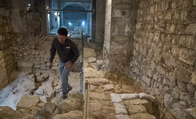 The Jerusalem Regional Archaeologist for the Israel Antiquities Authority, Dr. Amit Re'im, walks in a section of an excavation site where, according to the institution, a city wall from the Hasmonean period, dating to the late 2nd century BCE, was uncovered under the Tower of David Citadel Museum, in the Old City of Jerusalem, Monday, Dec. 8, 2025. (AP Photo/Leo Correa)