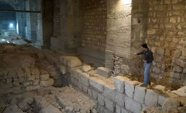The Jerusalem Regional Archaeologist for the Israel Antiquities Authority, Dr. Amit Re'im, shows a section of an excavation site where, according to the institution, a city wall from the Hasmonean period, dating to the late 2nd century BCE, was uncovered under the Tower of David Citadel Museum, in the Old City of Jerusalem, Monday, Dec. 8, 2025. (AP Photo/Leo Correa)