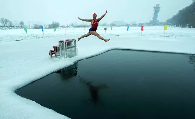 Yu Xiaofeng leaps as she jumps into a pool carved from ice on the frozen Songhua river in Harbin in northeastern China's Heilongjiang province, Tuesday, Jan. 7, 2025. (AP Photo/Andy Wong, File)