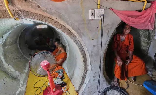 Abbot Phut Analayo, right, and other monks and residents who fled clashes between Thai and Cambodian soldiers, take shelter in Surin province, Thailand, Saturday, July 26, 2025. (AP Photo/Sakchai Lalit, File)