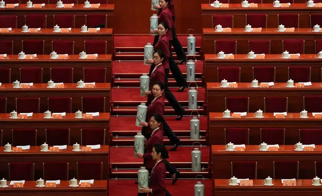 Hostesses fill up tea cups for the leaders before the opening session of the Chinese People's Political Consultative Conference at the Great Hall of the People in Beijing, Tuesday, March 4, 2025. (AP Photo/Andy Wong, File)
