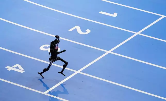 A robot competes in the 1500m race during the World Humanoid Robot Games in Beijing, China, Friday, Aug. 15, 2025. (AP Photo/Mahesh Kumar A., File)