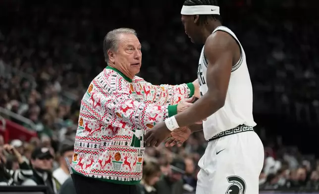 Michigan State head coach Tom Izzo, left, speaks with guard Trey Fort during the first half of an NCAA college basketball game against Oakland, Saturday, Dec. 20, 2025, in Detroit. (AP Photo/Ryan Sun)
