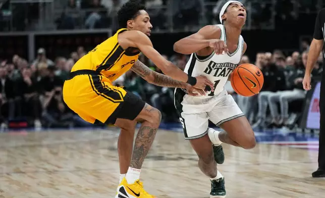 Michigan State guard Jeremy Fears Jr., right, is defended by Oakland guard Ziare Wells during the first half of an NCAA college basketball game, Saturday, Dec. 20, 2025, in Detroit. (AP Photo/Ryan Sun)
