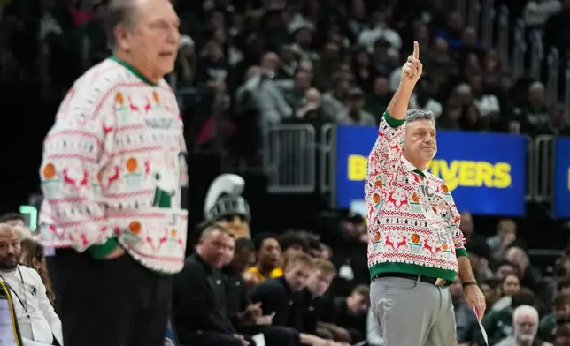 Oakland head coach Greg Kampe, right, gestures near Michigan State head coach Tom Izzo during the first half of an NCAA college basketball game, Saturday, Dec. 20, 2025, in Detroit. (AP Photo/Ryan Sun)